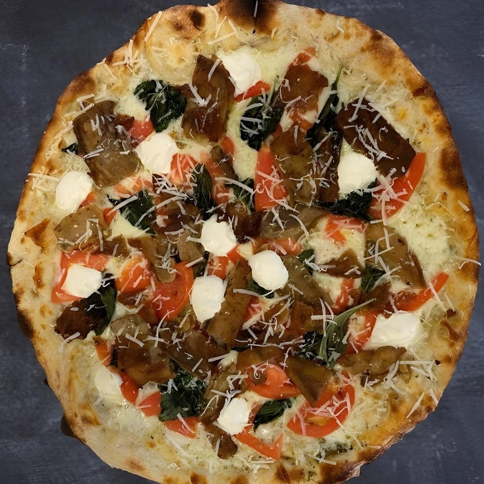 The Parlor's pizza with white sauce, tomatoes, basil, eggplant, and shredded cheese.
