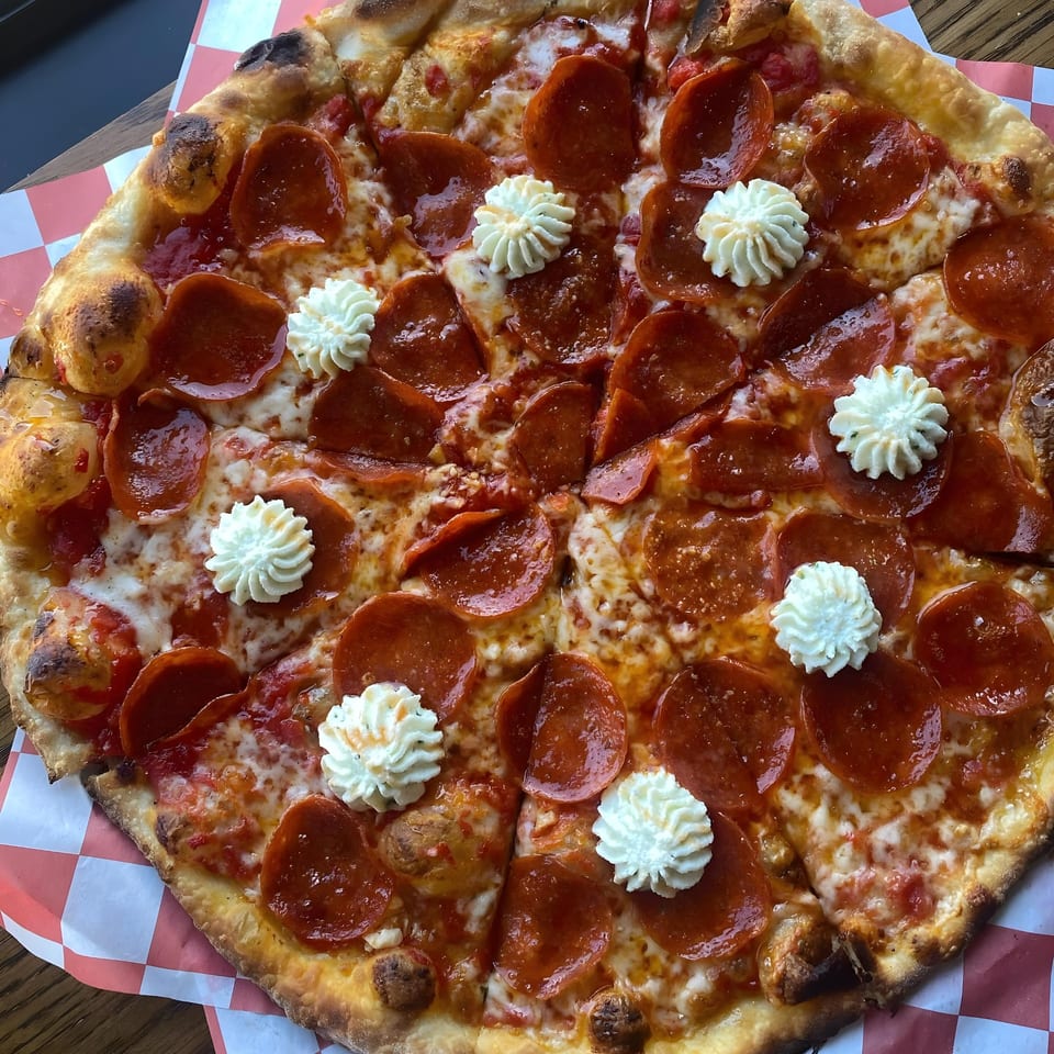 A whole pepperoni pizza from The Parlor, topped with dollops of whipped ricotta cheese.